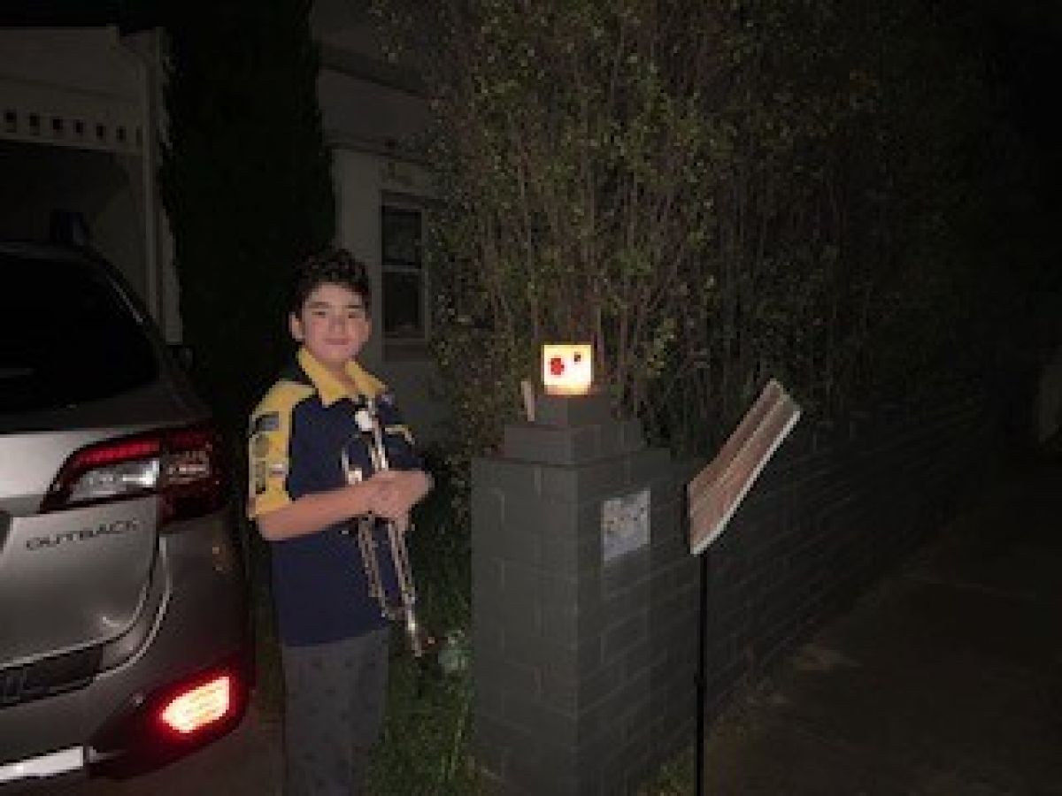 Student on trumpet playing outside their house