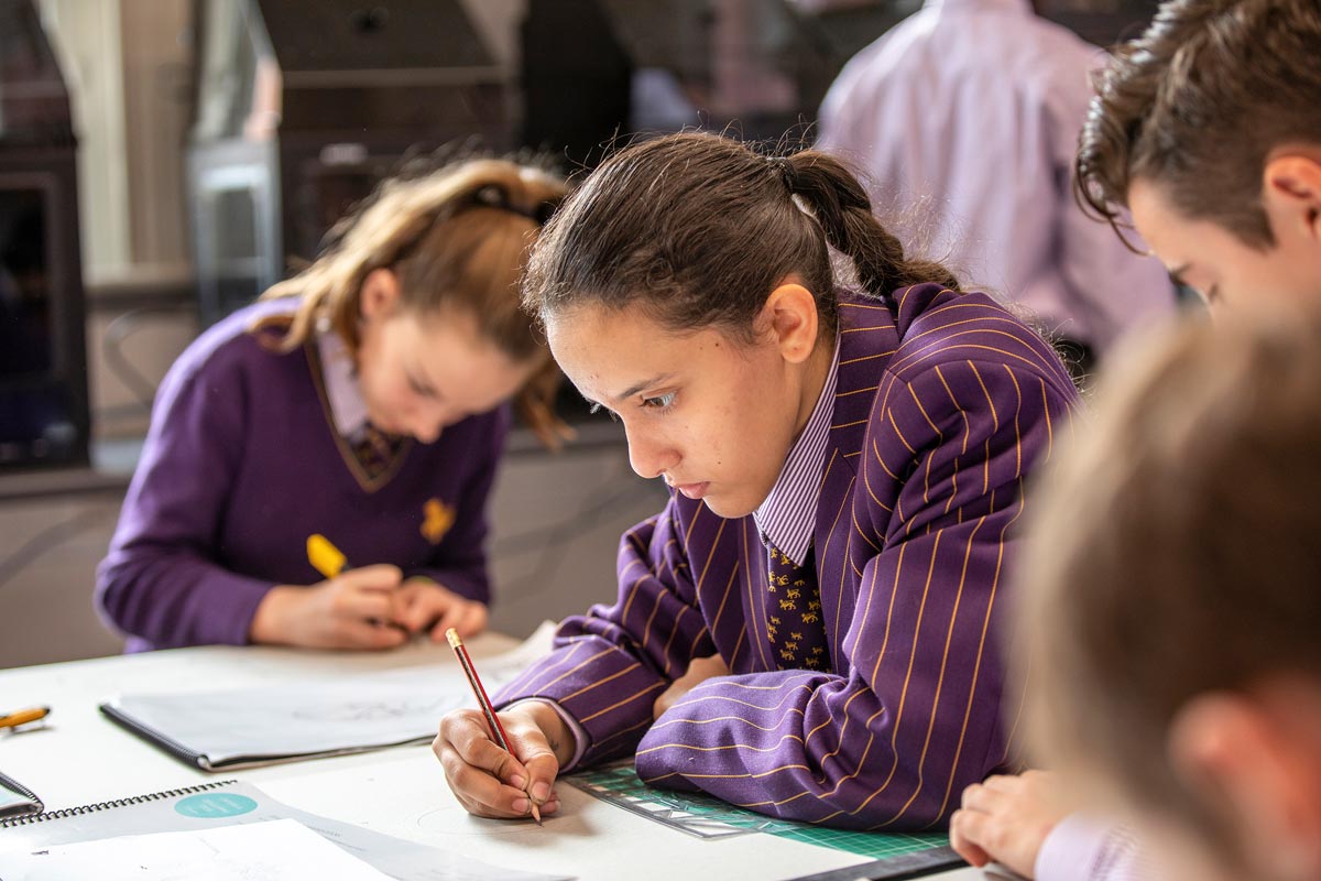 Girl in Wesley blazer studies at desk