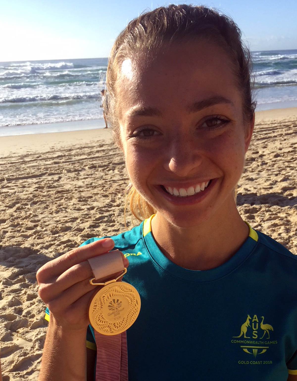 Elite athlete Jemima Montag holding up her gold Commonwealth Games medal