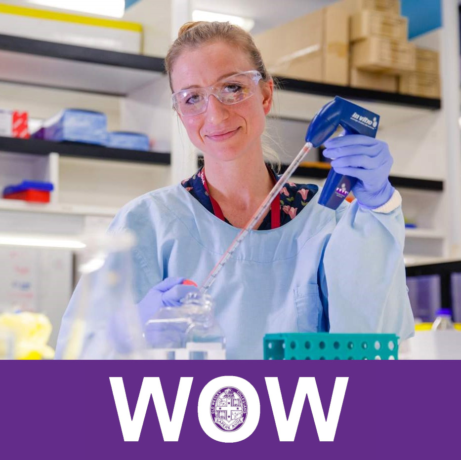 Kirsty Short in a science lab holding a piece of equipment