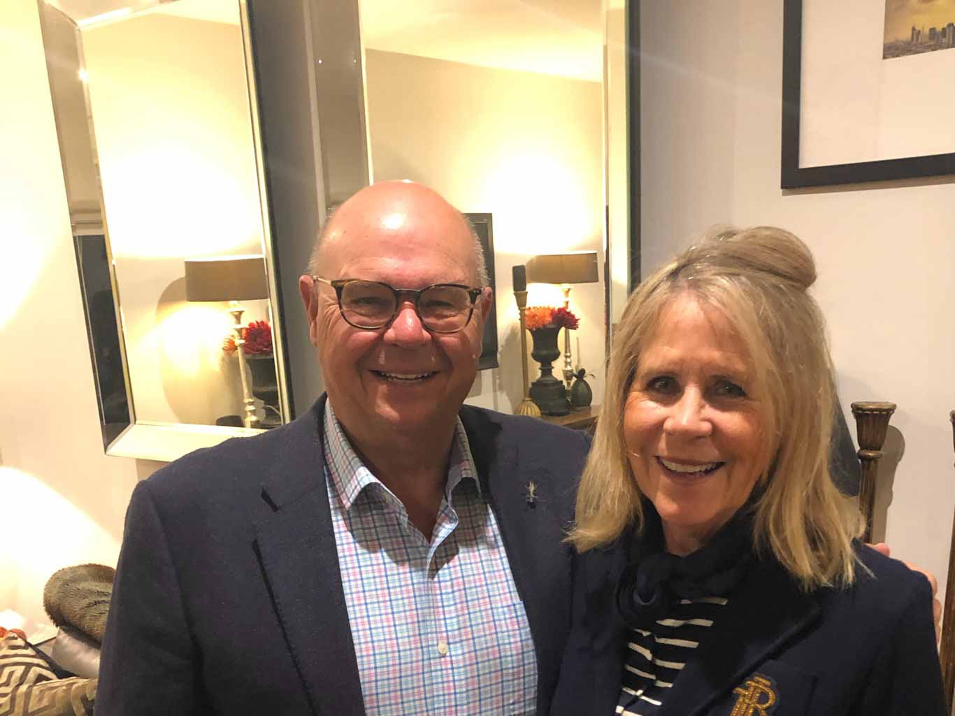 Bernard and Debbie standing in a room with a mirror behind them